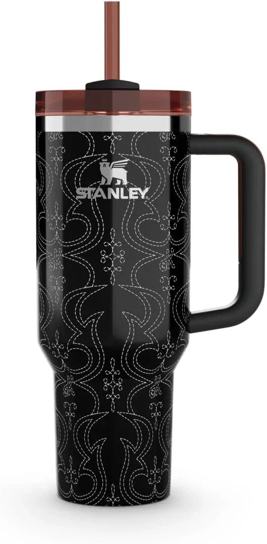 Black Stanley travel mug with intricate white stitched pattern, large handle, and brown lid with straw