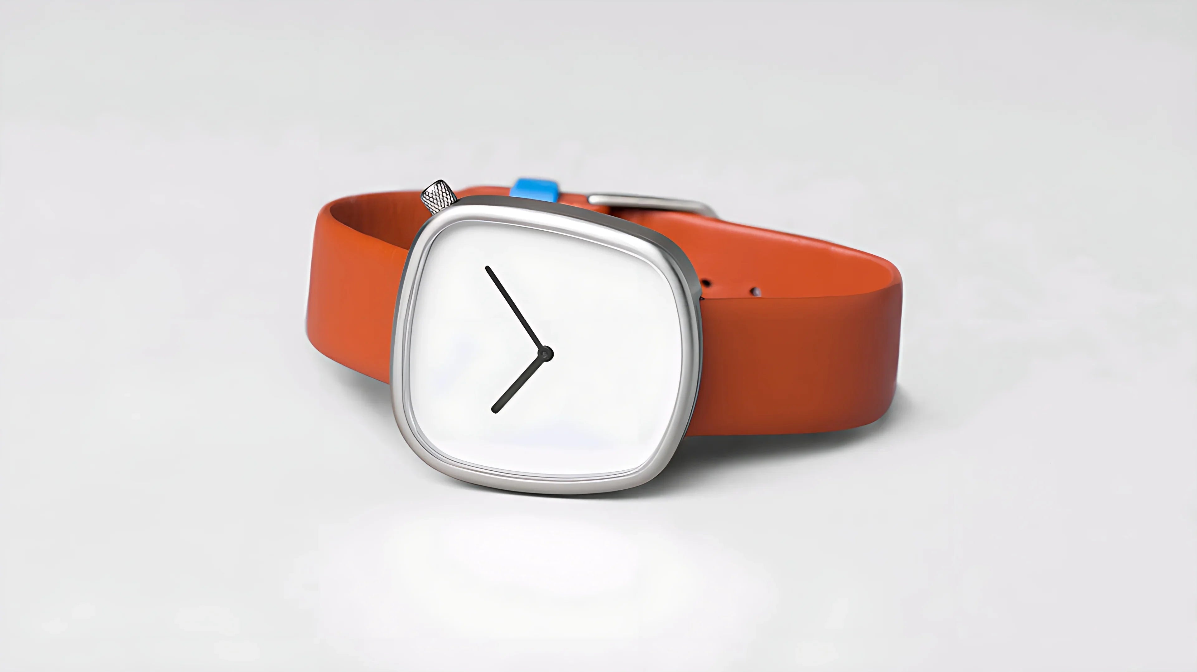Modern wristwatch with a square silver case and orange leather strap on a white background