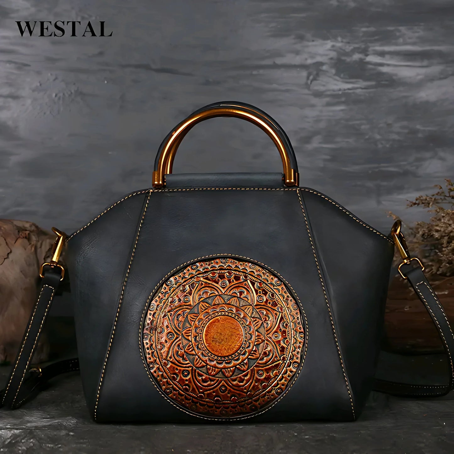 Black leather handbag with intricate embossed circular design and gold-tone handle accents