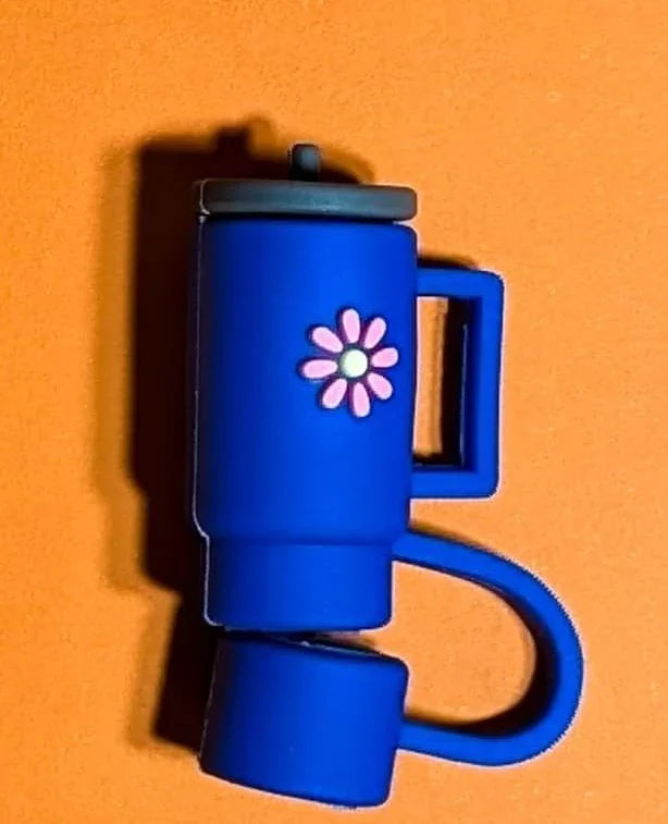 Blue travel tumbler with pink flower design and gray lid on orange background