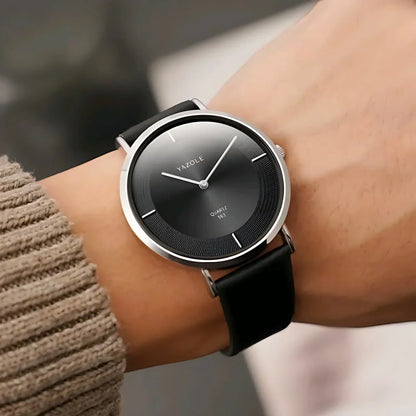 Yazole minimalist black dial quartz wristwatch with silver case and black leather strap on wrist