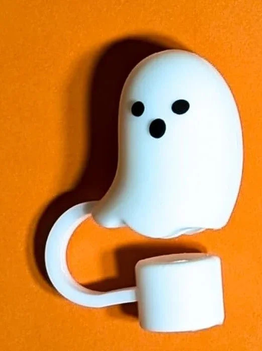 White ghost-shaped silicone ring accessory with expressive black eyes and mouth on orange background