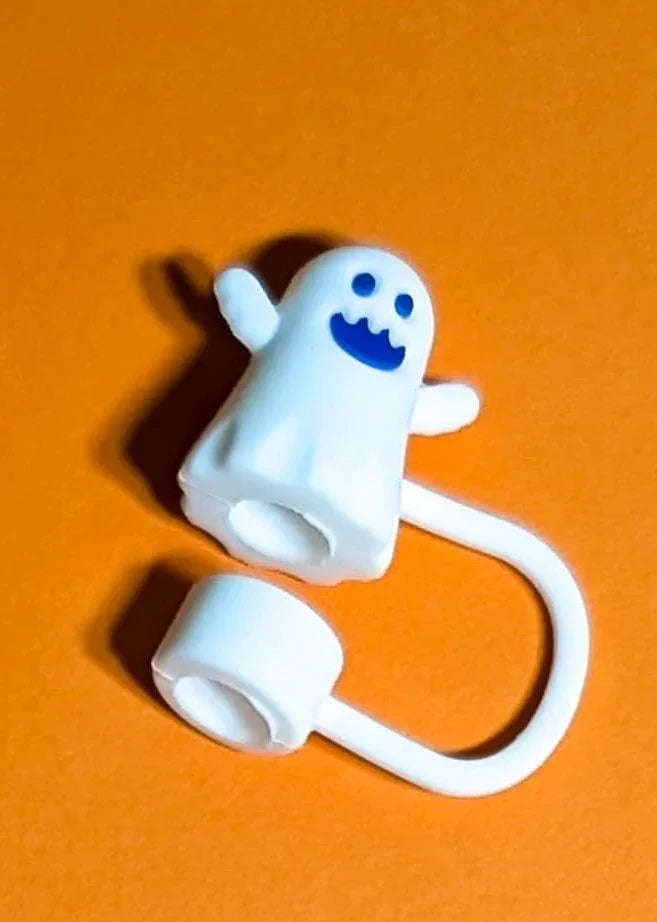 White rubber cable organizer shaped like a smiling ghost on orange background