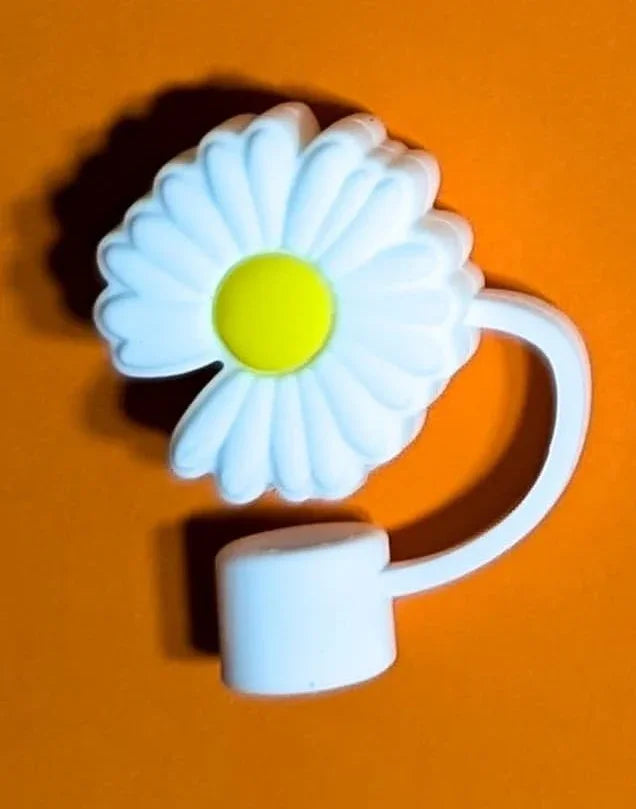 White plastic daisy flower with a yellow center on orange background, toy or decoration