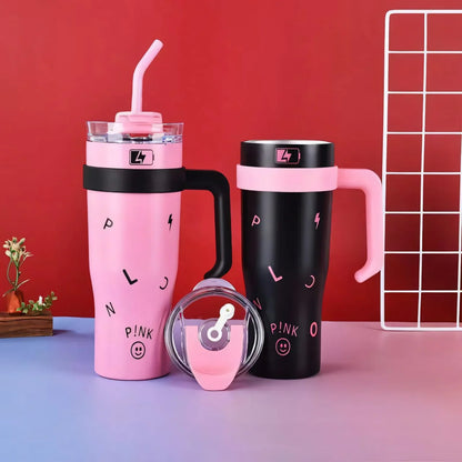 Pink and black insulated travel mugs with handles and straws on a blue and red background
