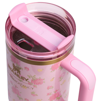 Pink Stanley travel mug with floral design and pink lid, featuring Stanley logo and handle