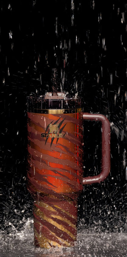 Stanley insulated travel mug with tiger stripe design and water splashing on black background