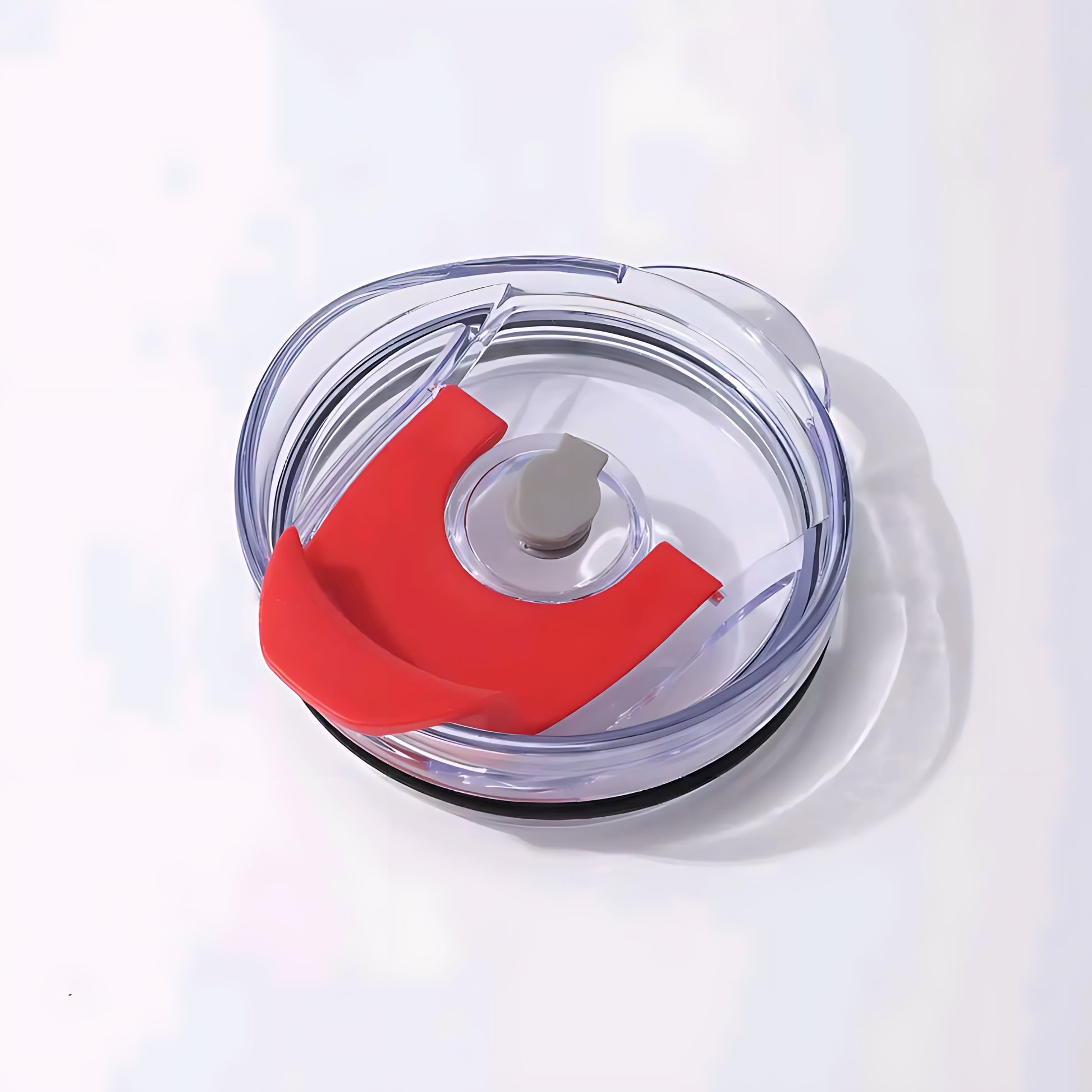 Clear circular food processor bowl with red silicone splash guard and lid on white background