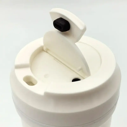 White plastic travel coffee mug lid with flip-open drinking spout and secure stopper