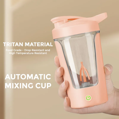 Hand holding a peach-colored automatic mixing cup made of food grade Tritan material with clear body and green power button