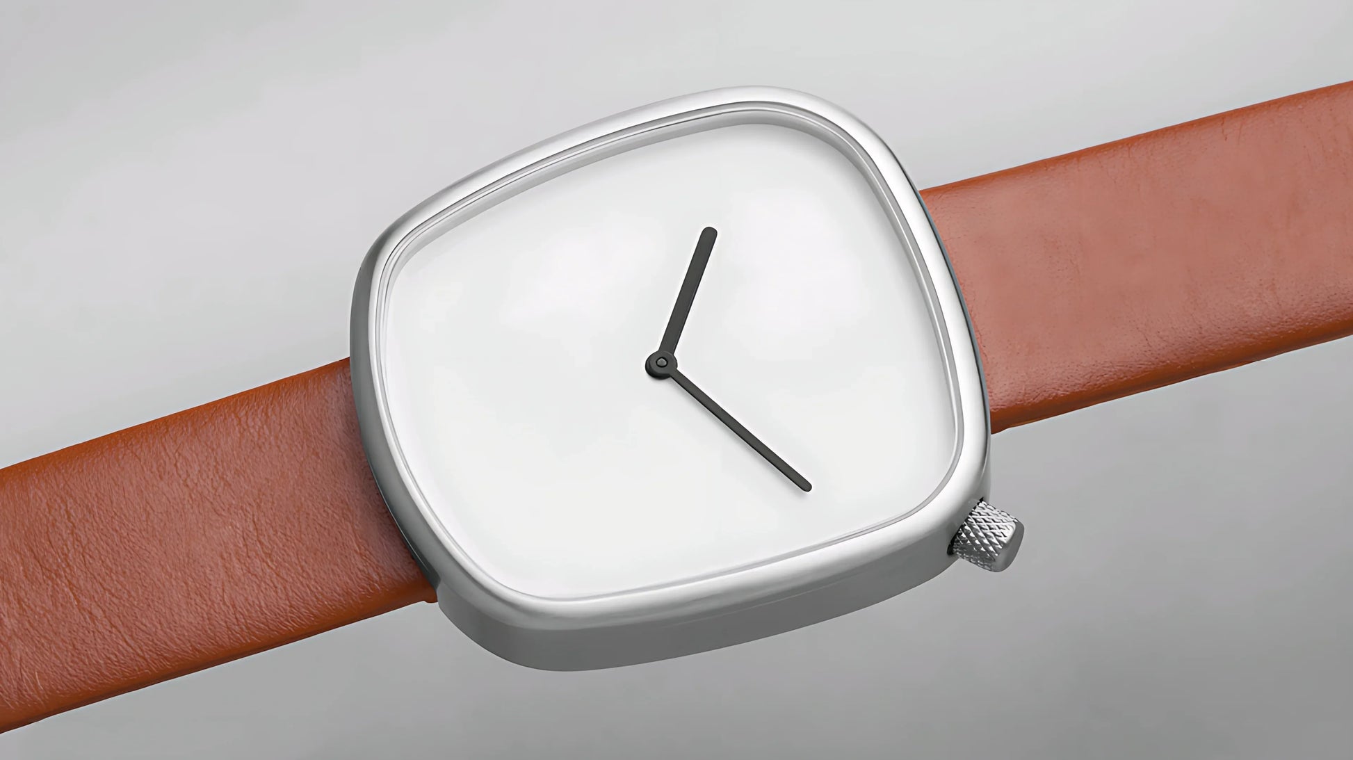 Minimalist wristwatch with silver irregular square case, white dial, black hands, and brown leather strap
