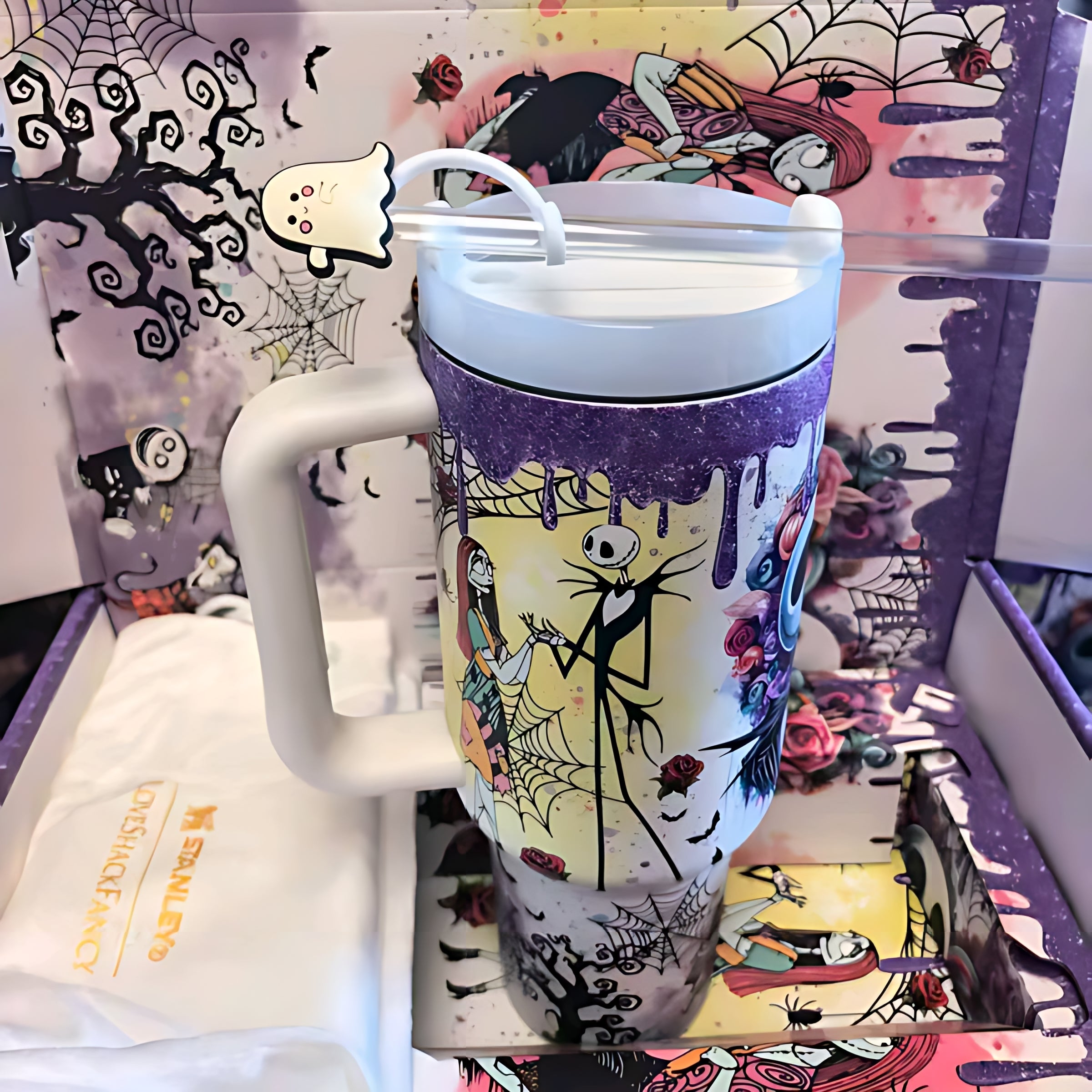 Nightmare Before Christmas themed travel mug with Jack Skellington, Sally, spider webs, and purple drip design