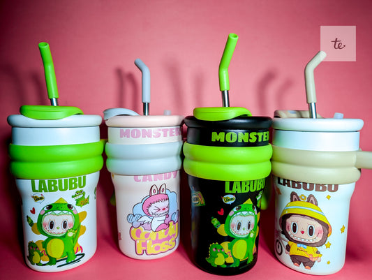 Four cute cartoon-themed sippy cups with straws on a pink background, featuring Labubu and Monster designs