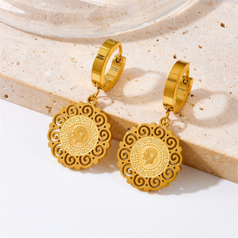 Pair of gold-tone hoop earrings with intricate filigree coin pendants featuring a profile engraving