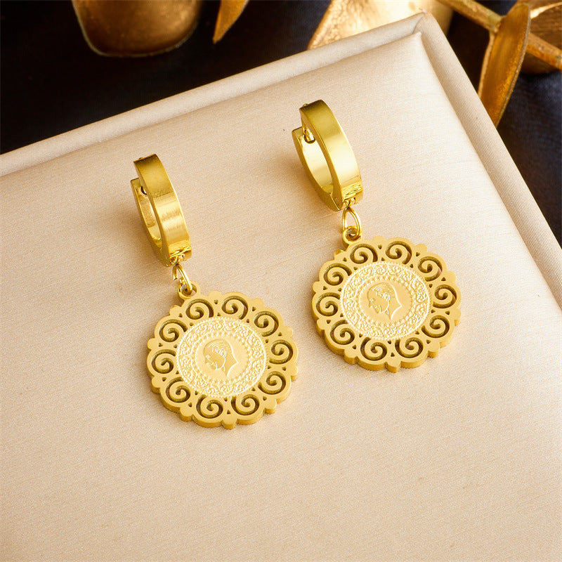Gold hoop earrings with intricate round pendants featuring a cameo profile design